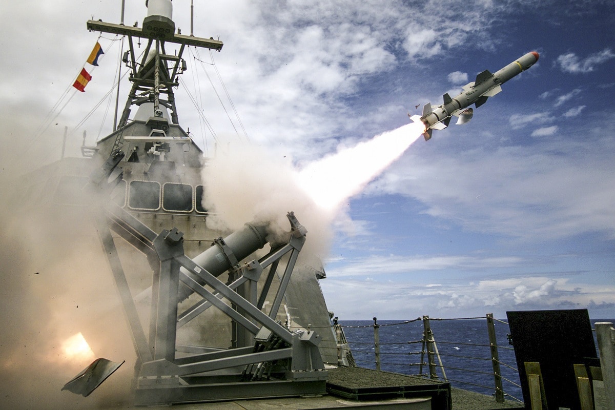Missile launching from a canister on a naval ship at sea.