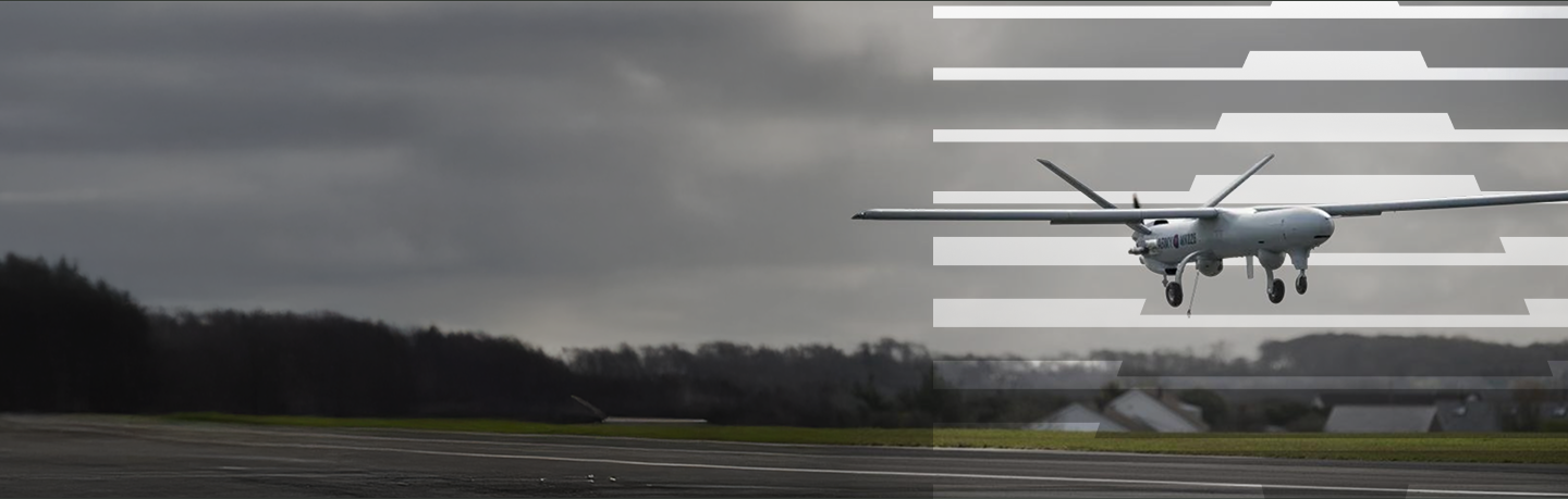 Military drone landing on a runway.